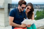 Young Tourist Couple In Town Holding A Map Stock Photo