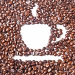 White Coffee Cup In Many Brown Coffee Beans For Background Stock Photo