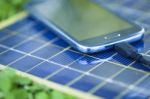 Charging Mobile Phone With Solar Charger Stock Photo