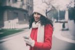 Beautiful Woman In Red Coat And Wool Cap And Gloves With Smartph Stock Photo