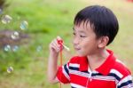 Asian Child Blowing Soap Bubbles In Summer Park, Nature Backgrou Stock Photo