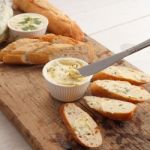 Baguette With Herb Butter And Rosemary Thyme On Rustic Wooden Background Stock Photo