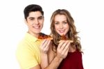 Couple Enjoying Pizza Slices Together Stock Photo