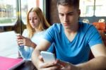 Group Of Friends Using Mobile Phone In Cafe Stock Photo