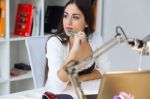 Pretty Young Woman Working With Laptop In Her Office Stock Photo