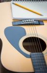 Yellow Acoustic Guitar On Wooden Table Stock Photo