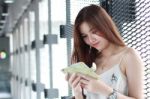 Portrait Of Thai Adult Beautiful Girl Using Her Smart Phone And Smile Stock Photo