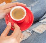 Woman In Torn Jeans Sitting At Coffee Shop Stock Photo