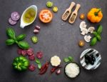 The Ingredients For Homemade Pizza On Dark Stone Background Stock Photo