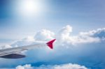 Cloudy Sky And Red Airplane Wing As Seen Through Window On Aircr Stock Photo