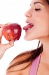 Closeup Of Young Girl Tasting The Apple By Her Tounge Stock Photo