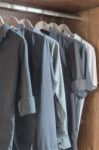 Clothes Hanging In Wooden Wardrobe Stock Photo