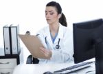 Doctor Woman Sitting On Her Office Making Notes Stock Photo