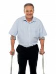 Senior Man Standing With Crutches Stock Photo