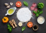 The Ingredients For Homemade Pizza On Dark Stone Background Stock Photo