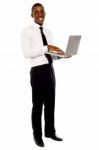 Smiling Businessman Holding Laptop Stock Photo