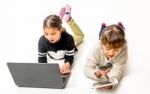 Little Girls Playing Games On The Notebook And Tablet Isolated On White Stock Photo