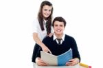 Schoolgirl Guiding Her Boy Friend Stock Photo