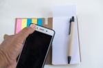 Mobile Phone Notebook And Pen On White Background Stock Photo