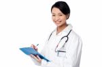 Pretty Female Doctor Writing Prescription Stock Photo