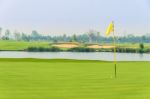 Golf Ball On Green Near Hole With Yellow Flag Stock Photo