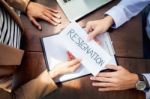 Hand Of A Businessman Hands Over A Resignation Letter On A Woode Stock Photo