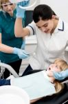 Lady Dentist Checking Girl's Teeth Stock Photo