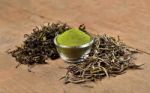 Dried Tea Leaf And Powder On Wooden Background Stock Photo