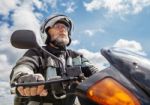 Elderly Motorcyclist Wearing A Jacket And Glasses With A Helmet Stock Photo