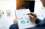 Business Man Working At Office With Laptop, Tablet And Graph Dat Stock Photo