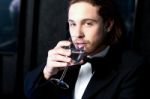 Guy In Tuxedo Drinking Cocktail Stock Photo