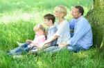 Happy Family Relaxing In Park Stock Photo