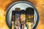 Oil Paint Brushes On Wood Painted Background Stock Photo