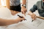 Architects Engineer Discussing At The Table With Blueprint - Clo Stock Photo