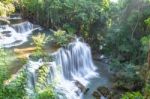 The Water Flowing Over Rocks And Trees Down A Waterfall At Huay Mae Khamin Waterfall National Park ,kanchana Buri In Thailand Stock Photo