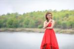 Beautiful Woman Wear Red Evening Dress Over Mountains And Rivers Stock Photo