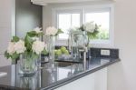 Glass Vase Of Flower On Black Granite Counter Stock Photo