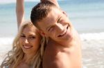 Smiling Couples At Beach Stock Photo