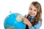 Disciplined Child Pointing At Something On Globe Stock Photo