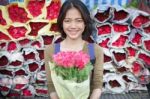 Smiling Face Of Younger Asian Woman With Pink Roses Flower Bouquet In Hand Stock Photo