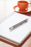 Pen On Open Blank White Notebook With Coffee Cup On The Desk Stock Photo