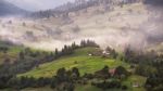 Alpine Village In Mountains. Smoke And Haze Over Hills Stock Photo