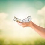 Hands Holding Us Dollars Note With Natural Background Stock Photo