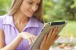 Beautiful Woman With Tablet Computer In Park Stock Photo