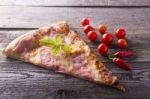 Pizza Cut On Wooden Table, Cherry Tomato And Hot Peppers Stock Photo