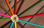 Multicolored Pencils On A Background Of Dark Wood Tables Stock Photo