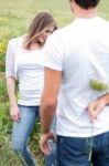 Rear View Of A Boyfriend Hiding A Flower Stock Photo