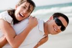 Young Couple Playing On Beach Stock Photo