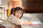 Asian Children With Yellow Pencil In Hand Doing School Home Work With Happiness Emotion Stock Photo