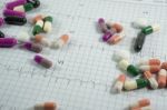 Heap Of Medicine Pills On Cardiogram Grid Paper. Selective Focus Stock Photo